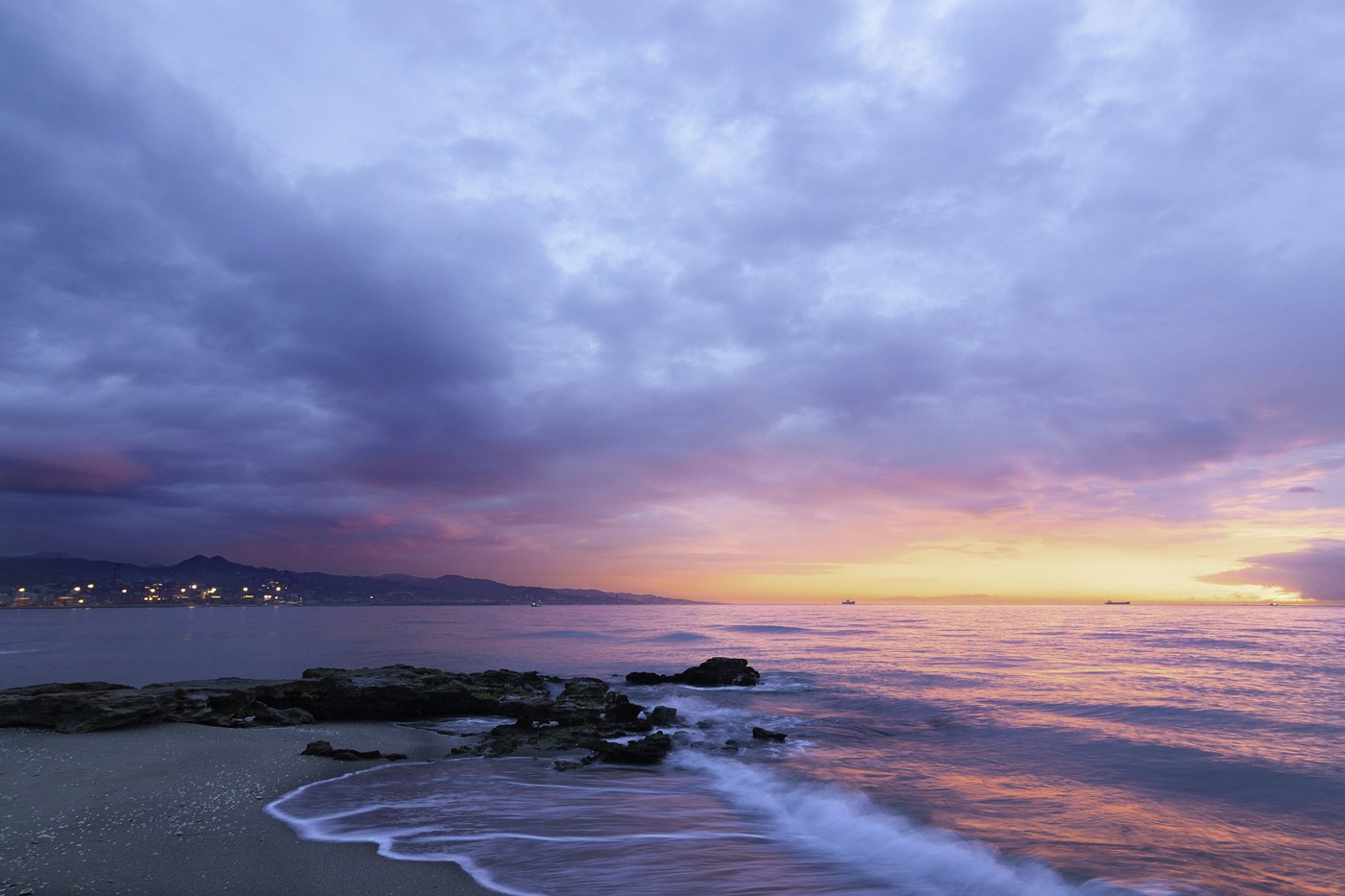 Luz rosa e laranja sobre o mar ao pôr do sol